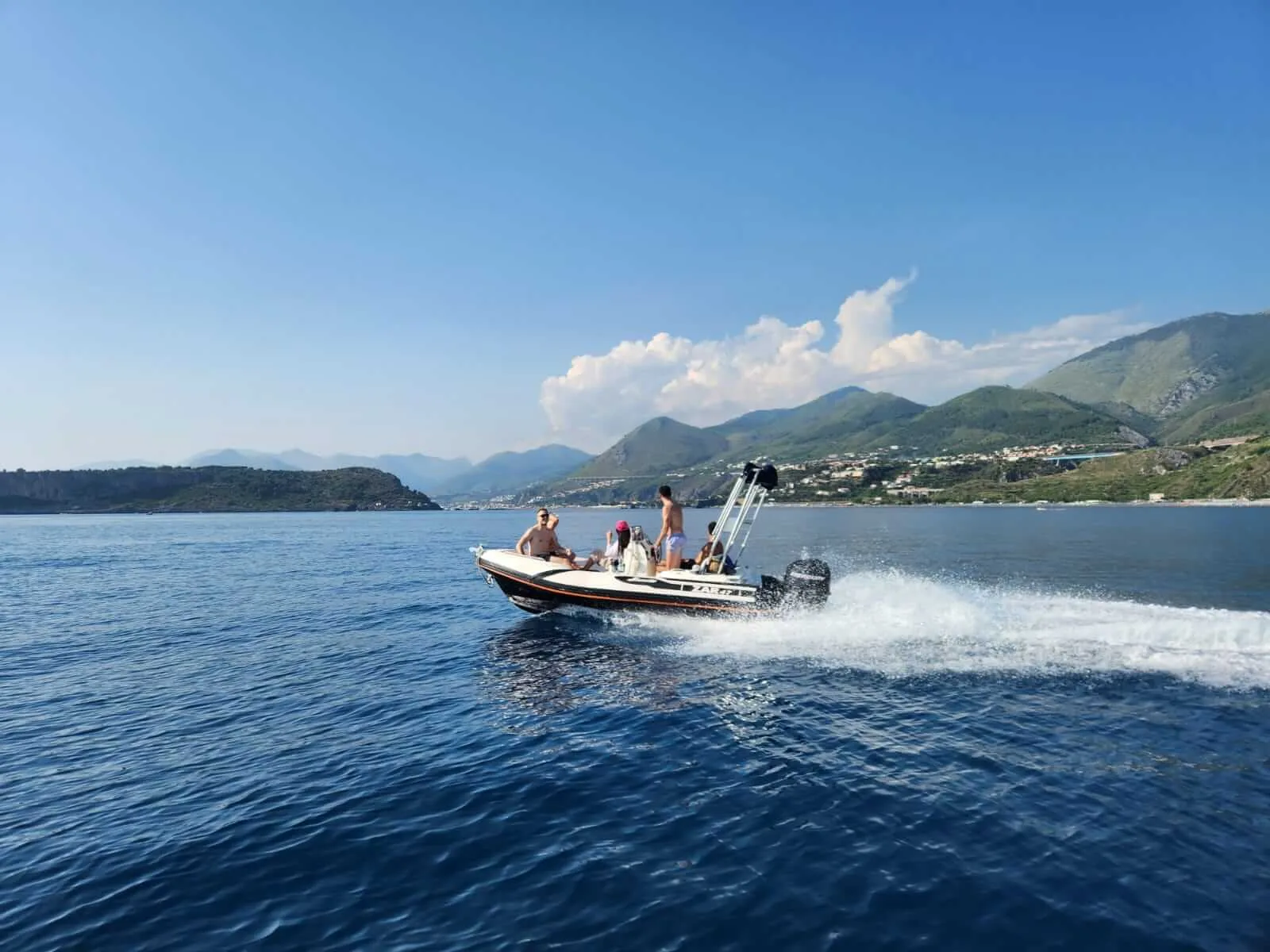 Lancha navegando por el mar con vista a las montanas de la costa de Basilicata, actividad de Remote Inn Tursi