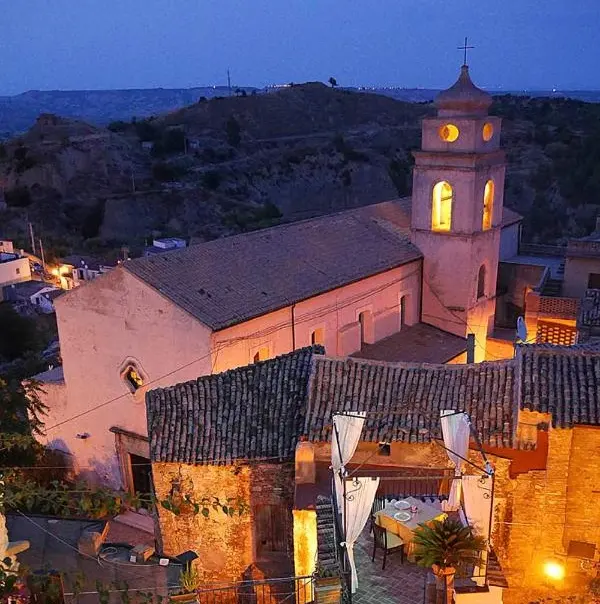 Vista nocturna de un pueblo historico del sur de Italia con campanario iluminado, destino de coliving de Tursi Digital Nomads